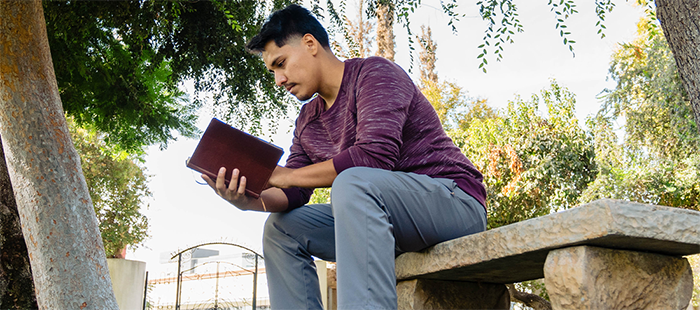 Hemophilia A patient, Daniel Cruz, reading a book on a bench