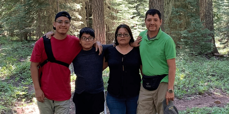 Hemophilia A Patient, Daniel Cruz, smiling with his family outside in nature