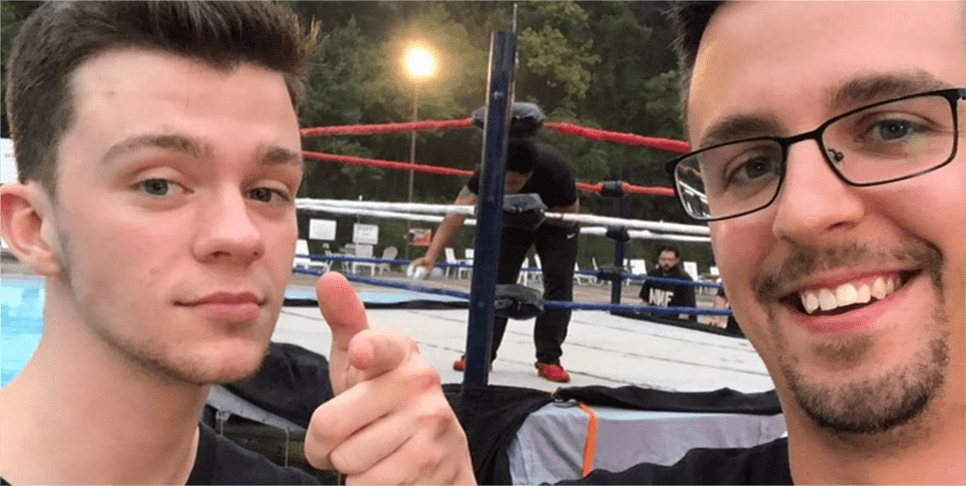 Rex Herald, paciente con hemofilia A, tomándose una selfie delante de un ring de lucha libre con otra persona