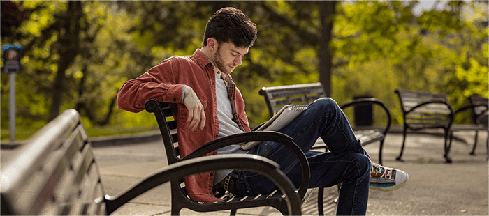 Rex Herald, paciente con hemofilia A, sentado en una banca de un parque con un libro