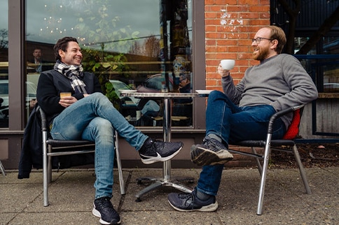 Hemophilia A patient, Billy Eshleman, having a discussion at an outdoor dining table.