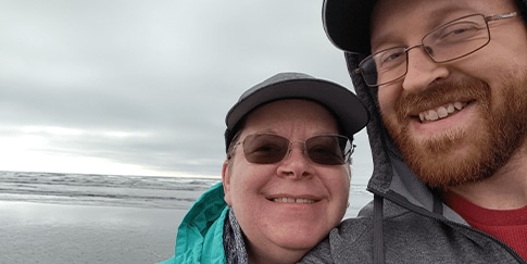 Billy Eshleman, paciente con hemofilia A, tomando una selfie con otra persona en la playa