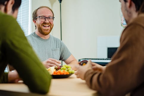 Hemophilia A patient, Billy Eshleman, smiling with two people sitting across from him.
