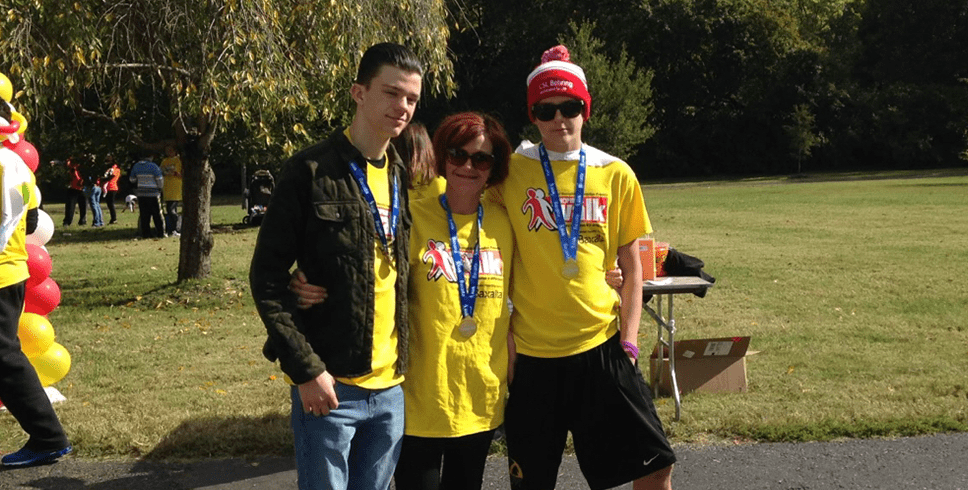 Rex Herald, paciente con hemofilia A, con su madre y su hermano en un evento con medallas colgando de sus cuellos