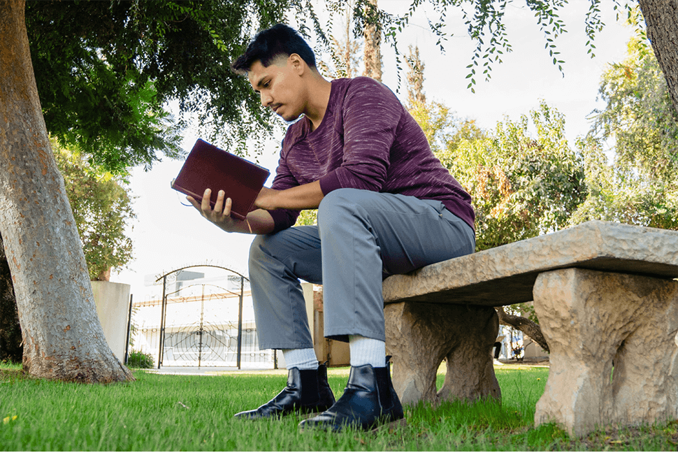 Hemophilia A patient, Daniel Cruz, reading a book on a bench